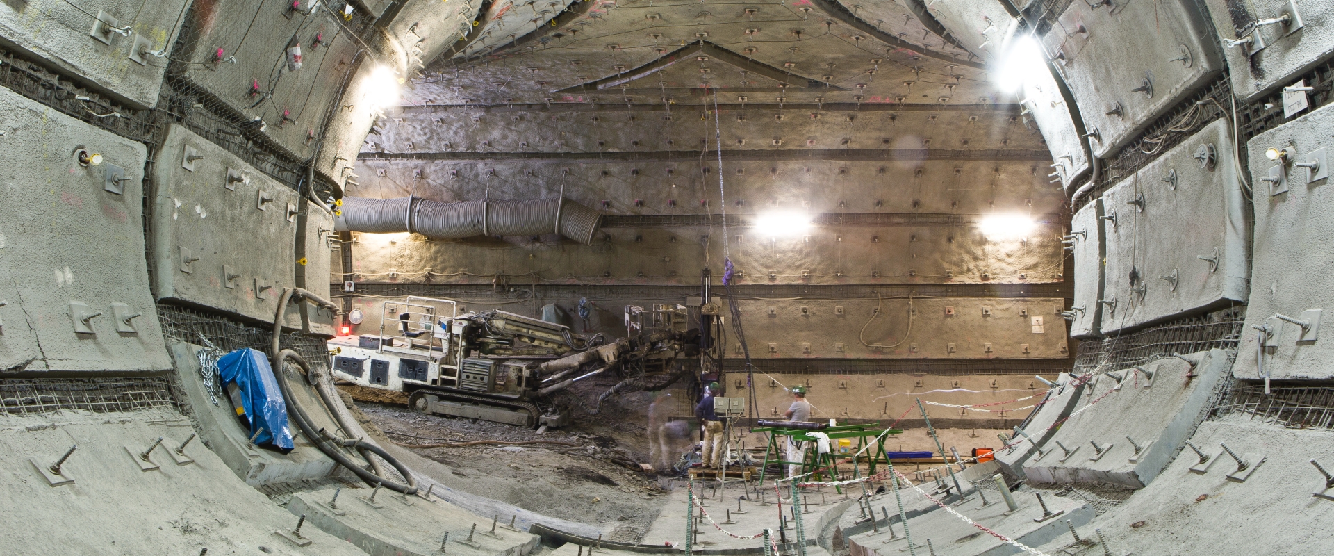 L&rsquo;image montre des employ&eacute;s de Redpath travaillant sur un chantier actif &agrave; l&rsquo;int&eacute;rieur d&rsquo;un grand tunnel circulaire o&ugrave; les murs semblent &ecirc;tre renforc&eacute;s avec des mailles m&eacute;talliques et sont parsem&eacute;s de nombreux boulons et fixations.